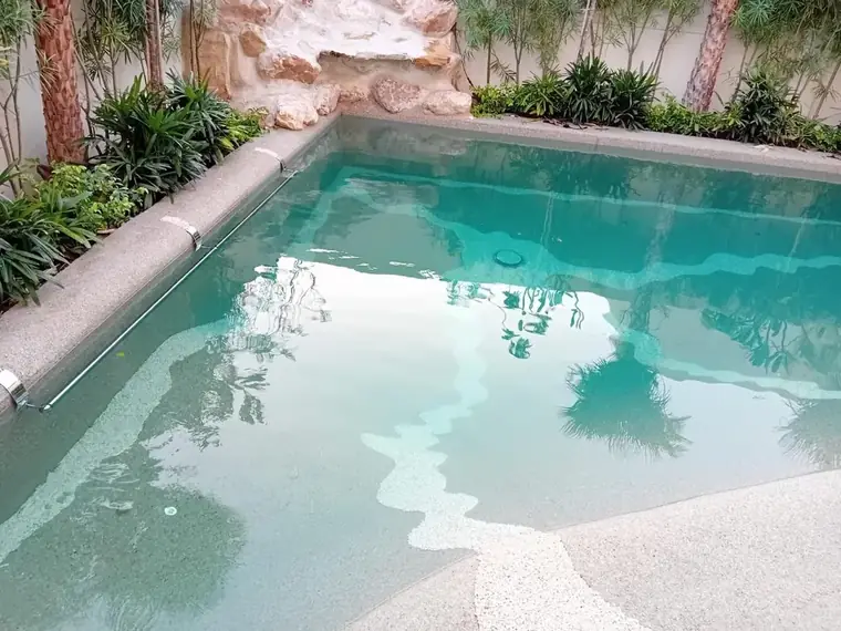 Beach pool surrounded by planting and stone